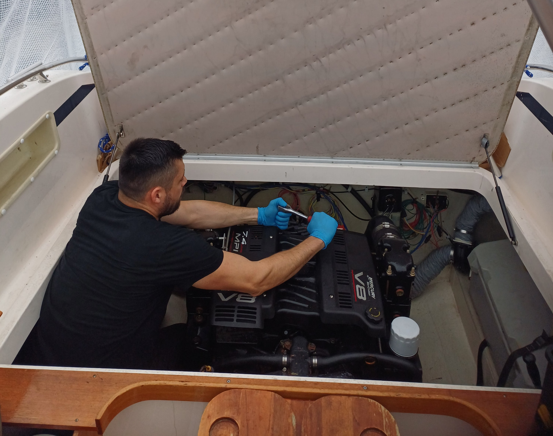 Mekaniker som jobber med en Mercury V8 innenbordsmotor i motorbrønn